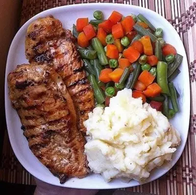 a plate of food with meat mashed potatoes and vegetables at 77 apartment in Abū aş Şalīḩ