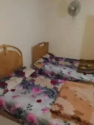 a bedroom with a bed with flowers on it at 77 apartment in Abū aş Şalīḩ