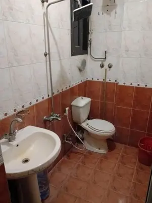 a bathroom with a toilet and a sink at 77 apartment in Abū aş Şalīḩ