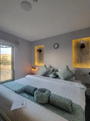 a bedroom with a large white bed with blue pillows at Petra Masterpiece in Wadi Musa