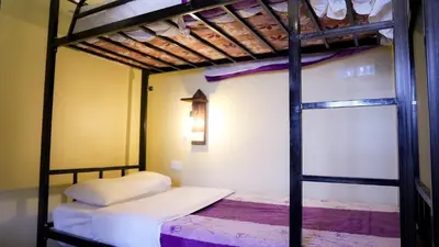 two bunk beds in a room with a ladder at Rafiki Hostel in Wadi Musa