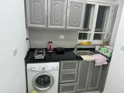 a kitchen with a sink and a washing machine at Ahlam Apartments in Amman