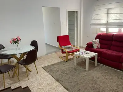 a living room with a red couch and a table at Ahlam Apartments in Amman