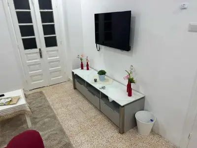a living room with a tv on a white wall at Ahlam Apartments in Amman