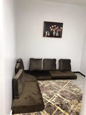 a living room with a brown couch in a room at رزق هاوس in Ash Shūnah ash Shamālīyah