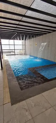 a large swimming pool with a fountain in a building at LAVA Resort Hot spring water in Mukāwir