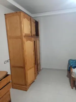 a room with a wooden cabinet in the corner at غباوي موتل in Az Zarqa
