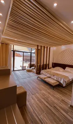 a bedroom with a large bed and a large window at مخيم خيال رم in Jurf ad Darāwīsh