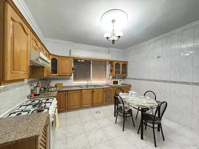 a kitchen with a table and chairs and a kitchen with a stove at شقة مفروشة للايجار مميزه هادئه امنه ذات اطلاله رائعه in Amman