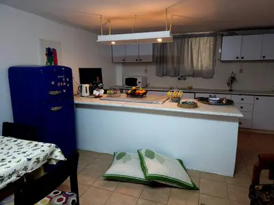 a kitchen with a counter and a blue refrigerator at Cozy Home with a Lovely Garden in Jurf ad Darāwīsh