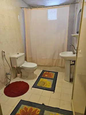a bathroom with a toilet and a sink at Cozy Home with a Lovely Garden in Jurf ad Darāwīsh