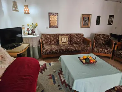 a living room with a bowl of fruit on a table at Cozy Home with a Lovely Garden in Jurf ad Darāwīsh