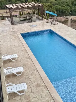 a swimming pool with two lounge chairs next to it at Munifah Grand Hills Chalet and Farm in Jurf ad Darāwīsh