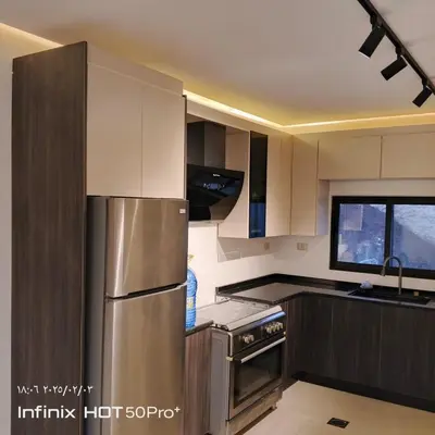 a kitchen with a stainless steel refrigerator and a window at Munifah Grand Hills Chalet and Farm in Jurf ad Darāwīsh