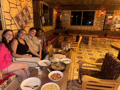 a group of people sitting around a table with food at Dana bedouin Sky in Dana