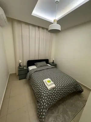 a bedroom with a black and white bed and a light at Cozy 3-Bedroom Apartment in Abdoun in Amman