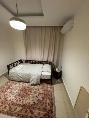 a bedroom with a bed with a rug on the floor at Cozy 3-Bedroom Apartment in Abdoun in Amman