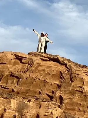 two people standing on top of a mountain at Sands of time desert camp in Wadi Rum