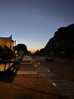 a beach with a row of benches on the sand at في اصحراء المريخ في وادي رم in Jurf ad Darāwīsh