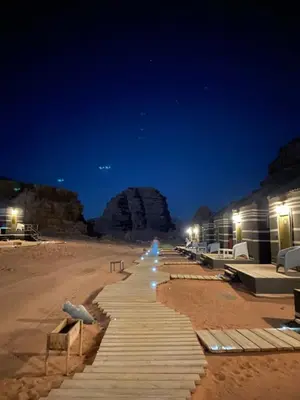 a beach at night with a building and lights at في اصحراء المريخ في وادي رم in Jurf ad Darāwīsh