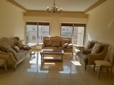 a living room with couches and a coffee table at Cosy family apartment in Amman in Amman