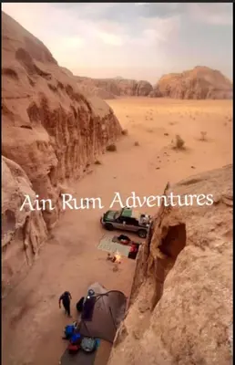 a view of a desert with a car parked in the desert at مغامرات عين رم in Wadi Rum