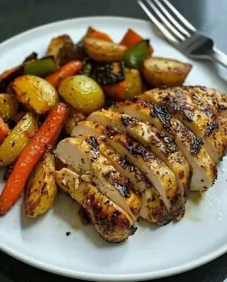 a plate of food with chicken and potatoes and vegetables at ام القطين لونج in Umm al Qiţţayn