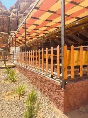 a wooden fence next to a building in the desert at Eram camp in Jurf ad Darāwīsh