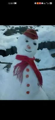 a snowman wearing a red scarf and a red hat at الاردن in Jurf ad Darāwīsh