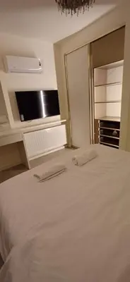 a bedroom with a large white bed with a mirror at LV luxury apartment Deir Ghbar in Amman