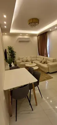 a living room with a couch and a table and chairs at LV luxury apartment Deir Ghbar in Amman