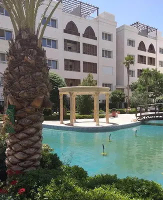 a swimming pool with a gazebo and a palm tree at LV luxury apartment Deir Ghbar in Amman