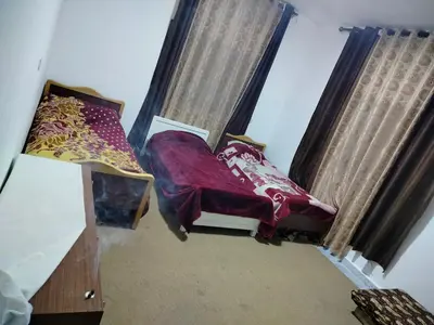 a bedroom with a bed and a couch and curtains at شقق ابو يزن عجلون بالقرب من محمية عجلون in Ajloun