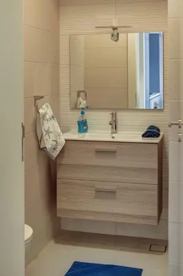 a bathroom with a sink and a mirror at Emerald Beach Apartment in Aqaba