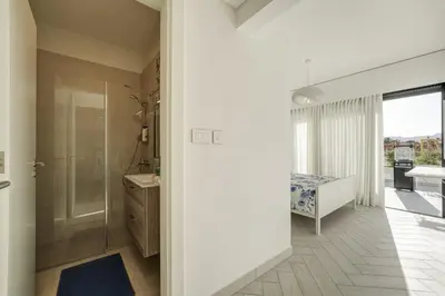 a bathroom with a shower and a sink and a mirror at Emerald Beach Apartment in Aqaba