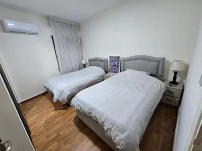 two beds in a small room with wood floors at Rainbow Retreat - 2BR in the heart of Old Amman in Amman