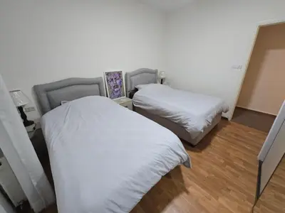 two beds in a room with white sheets at Rainbow Retreat - 2BR in the heart of Old Amman in Amman