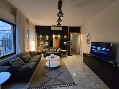 a living room with a couch and a tv at Rainbow Retreat - 2BR in the heart of Old Amman in Amman