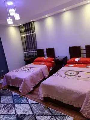 two beds in a room with purple walls at البويضه هاوس in Al Buwayḑah