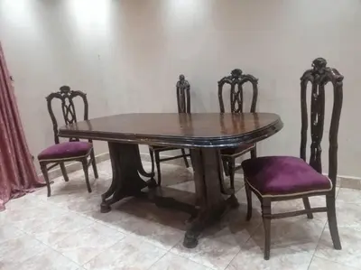 a wooden table and four chairs with purple seats at البويضه هاوس in Al Buwayḑah