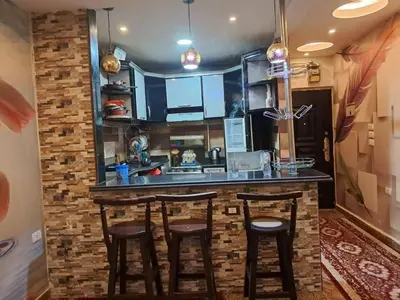 a kitchen with a counter with stools at a bar at البويضه هاوس in Al Buwayḑah