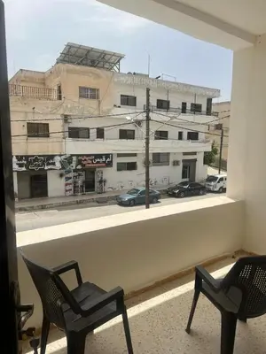 a room with two chairs and a view of a building at Altamem apartment in Um Qeis