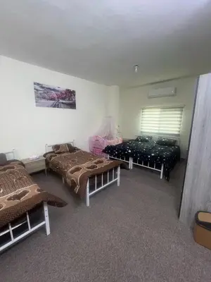 a room with two beds and a window in it at Altamem apartment in Um Qeis