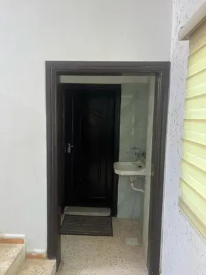 a bathroom with a black door and a sink at Altamem apartment in Um Qeis