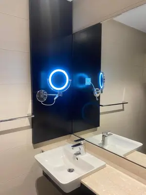 a bathroom with a sink and a mirror with a light at Boulevard luxury Studio in Amman