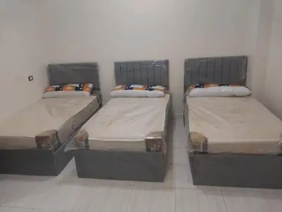 three beds are lined up in a room at الثغره هاوس in Abū al Lasan