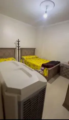 a room with a tv and a bed with yellow sheets at الثغره هاوس in Abū al Lasan