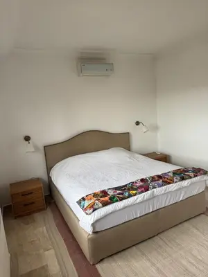 a bed in a bedroom with a white wall at The Olive- Bright, Spacious&Newly Renovated in Amman