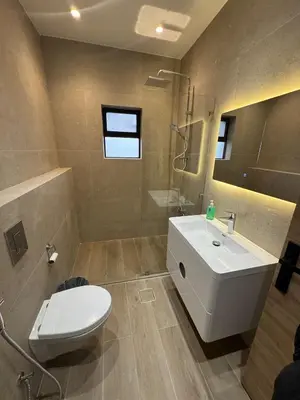 a bathroom with a white toilet and a sink at The Olive- Bright, Spacious&Newly Renovated in Amman