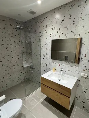 a bathroom with a sink and a shower and a toilet at The Olive- Bright, Spacious&Newly Renovated in Amman